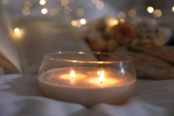 istock Burning candle on white cloth, closeup. Cozy atmosphere 2216806875