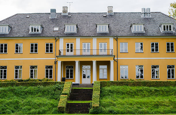 Architecture. Yellow building in front of the lawn.