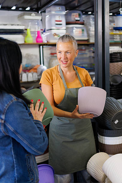 istock Shop Assistant Helping Woman Choose Planter 2216812111