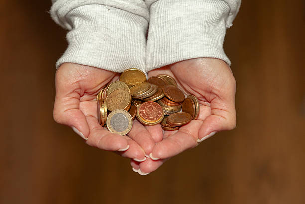 istock Woman's hand with coins in her hand 2216814440
