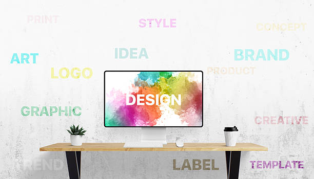 istock Office setup with digital screen and white wall filled with design-related terms like idea, logo, brand, and art â a visual language of creativity 2216817059