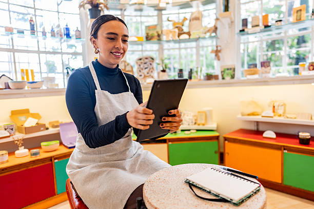 istock Female owner wearing apron, using digital tablet at the store 2216817147
