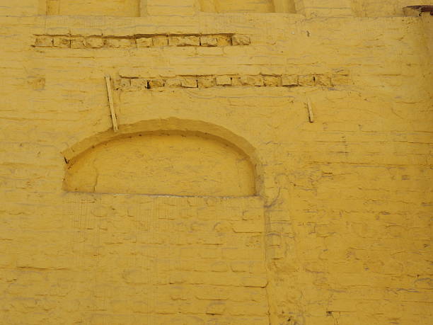 Historic facade with yellow wash and bricked-up openings. Space for texts and designs.