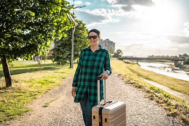 istock Woman Walking Outdoors With Luggage During Bright Sunny Day 2216818542