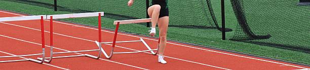 istock Female runner hits hurdle while running in a hurdle race 2216820849