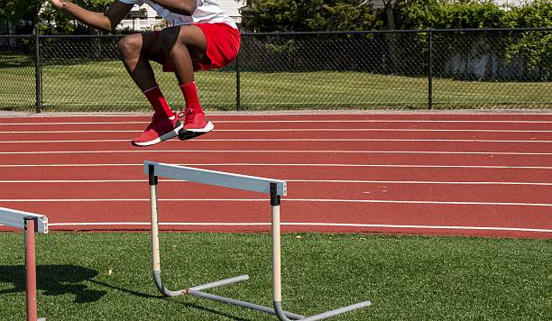 istock Young Athlete Jumps Over Hurdles Turf Field During Training 2216820870