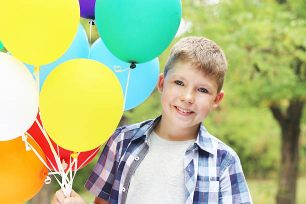 istock Llittle boy with balloons in the park 2216823940