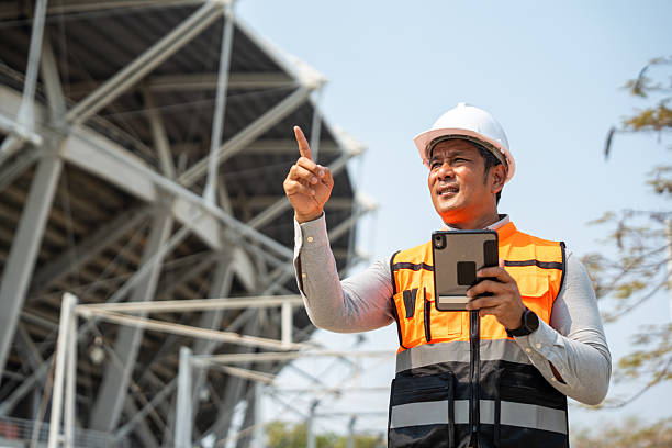 istock Asian senior engineer man or architect looking forward with white safety helmet in construction site. Standing at modern building construction. Professional asian man working project building 2216824833