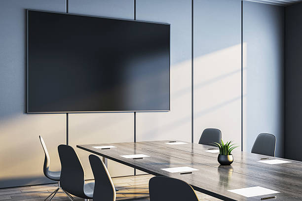 istock Modern corporate meeting room with large wall-mounted screen and minimalist interior design in natural daylight ambiance. 3D Rendering 2216829183