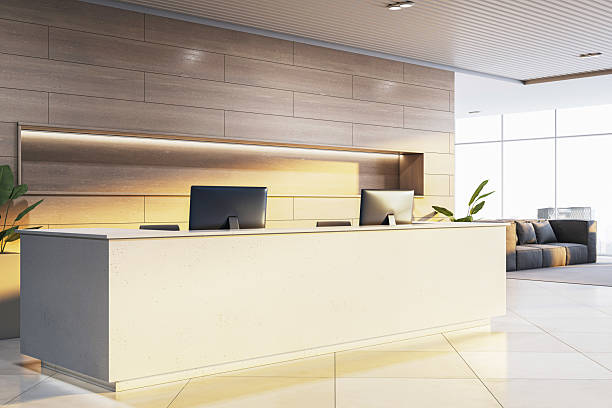 istock Modern corporate reception desk with clean beige counter and twin monitors in bright contemporary office interior with large windows and city view. 3D Rendering 2216829331