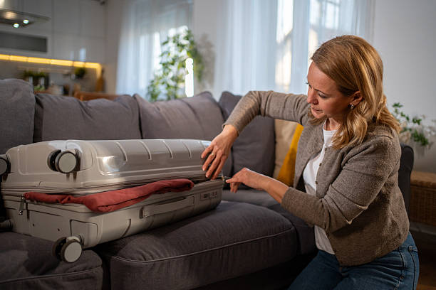 istock Woman closing her suitcase before leaving home for vacation 2216832849