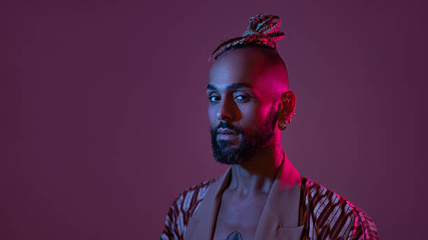 istock Neon light studio close-up portrait handsome black gay man looking camera. 2216833358