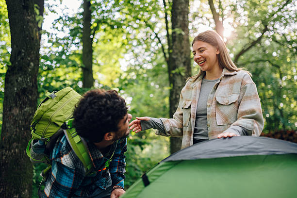 istock Happy campers setting up tent in forest 2216842551
