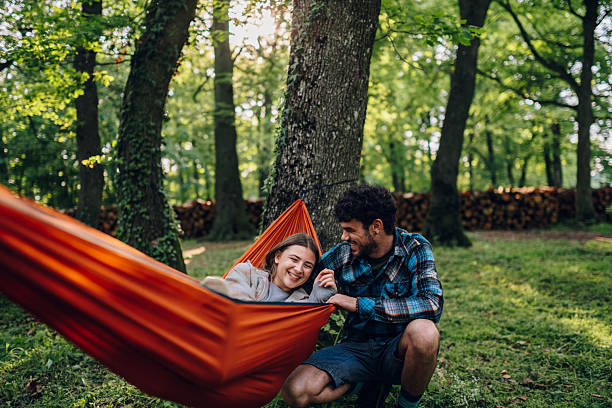 istock Happy couple relaxing and having fun in hammock at campsite 2216842628