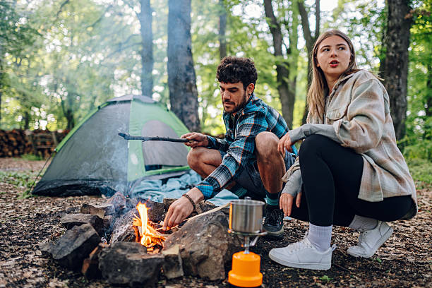 istock Couple camping and lighting campfire in forest 2216842868
