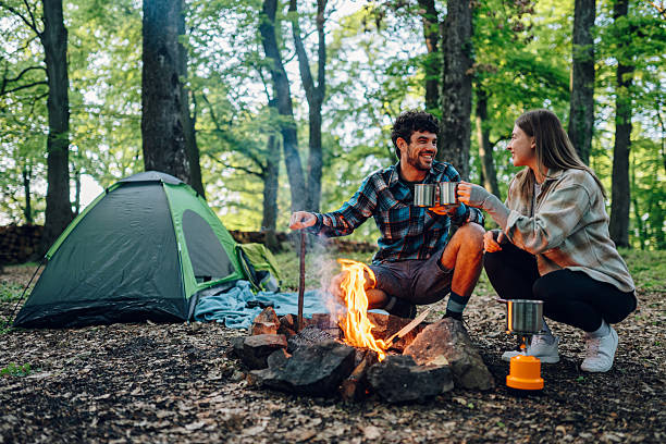 istock Hikers enjoying hot drinks by campfire in forest 2216842872