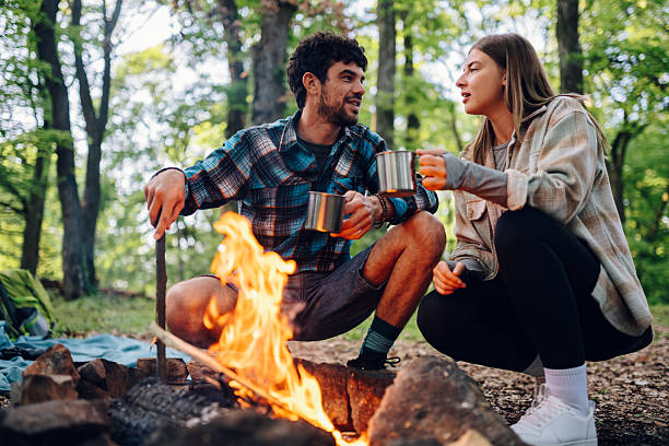 istock Hikers enjoying hot drinks by campfire in forest 2216842877