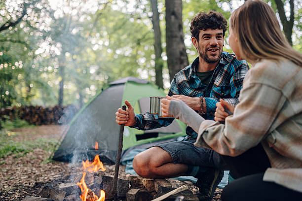 istock Hikers enjoying hot drinks by campfire in forest 2216843401