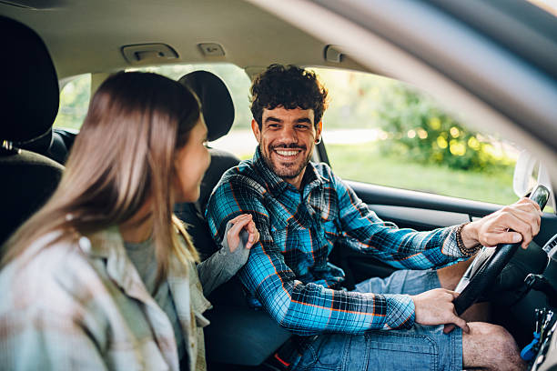 istock Happy couple driving and smiling during a road trip 2216843421
