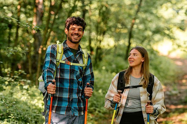 istock Hikers walking through forest using trekking poles and backpacks 2216843464