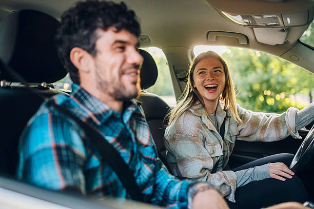 istock Young couple laughing and having fun while driving in car 2216843469