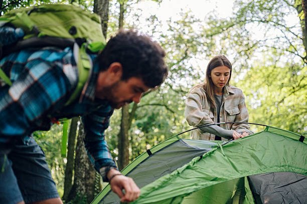 istock Hikers setting up tent in forest camping trip 2216843568