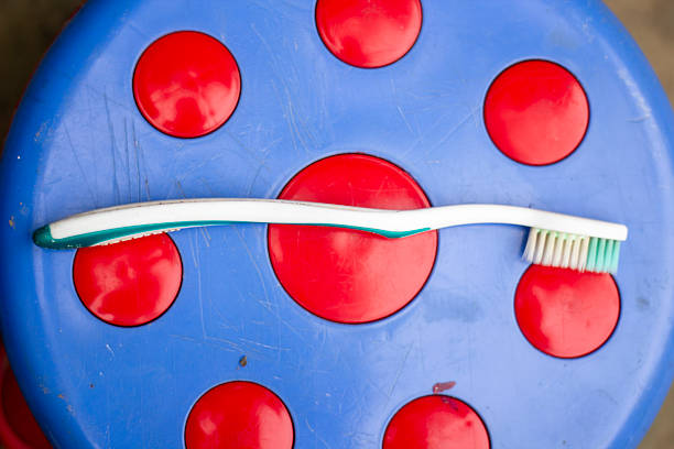 A Red toothbrush and azun facing each other on a green surface.