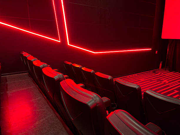 Empty red theater seats leading to the screen, creating a serene and inviting ambiance for an unforgettable cinematic experience.