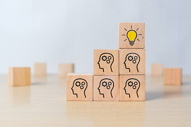 istock Wooden cube with head and light bulb icon. Symbol of creative idea, innovation, thinking process, and problem solving concept 2216847091
