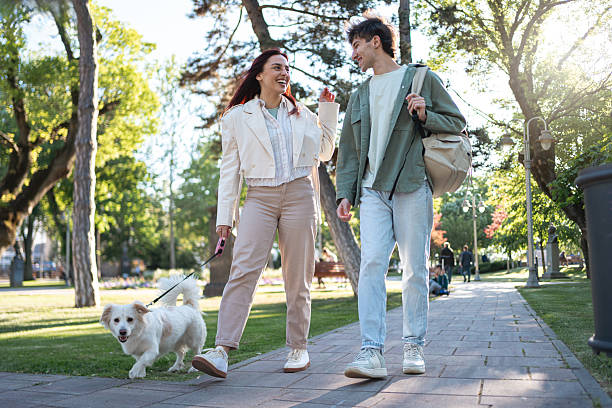 istock Young couple walking their dog on a path through a scenic park 2216848952