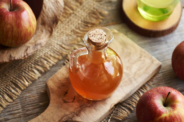 istock Apple cider vinegar in a glass bottle on a wooden table 2216856135