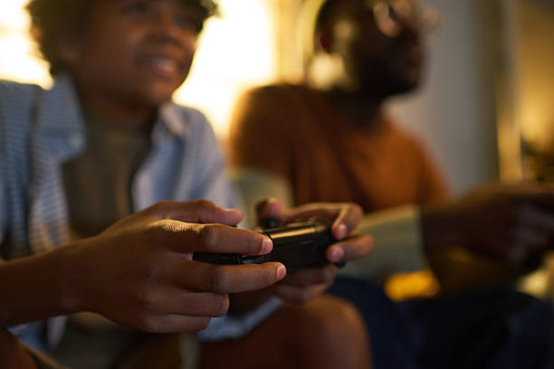 Two young women are giving each other high five while playing video games on the couch at home