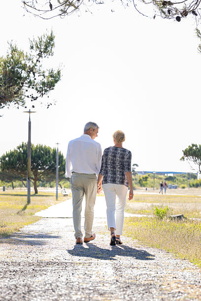 istock Senior couple walking in park holding hands 2216858574