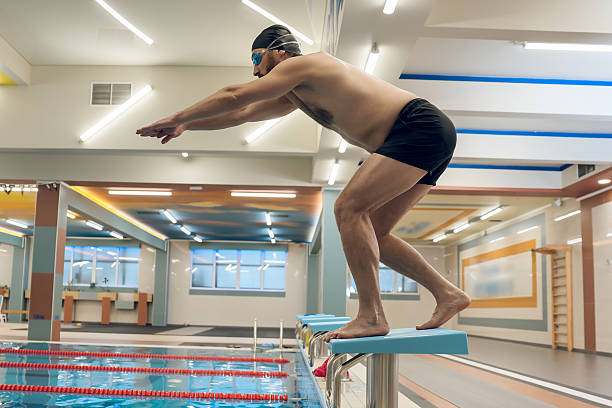 istock Man having a workout in the swimming pool and getting ready to jump 2216859639
