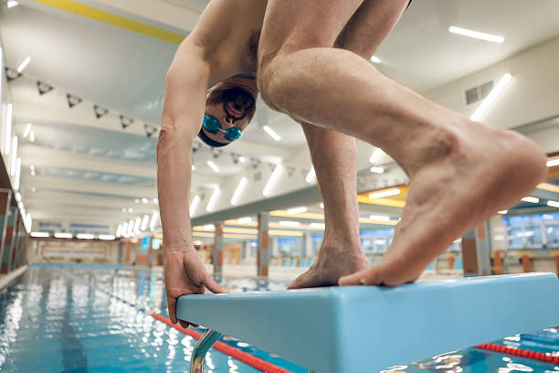 istock Man having a workout in the swimming pool and getting ready to jump 2216859641
