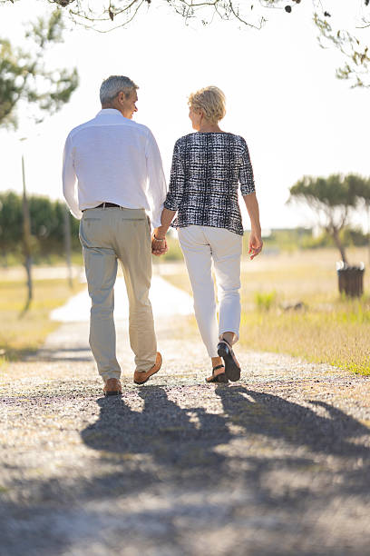 istock Happy senior couple walking on a path holding hands 2216860468