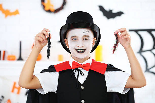 Young boy in halloween costume with insect in hands