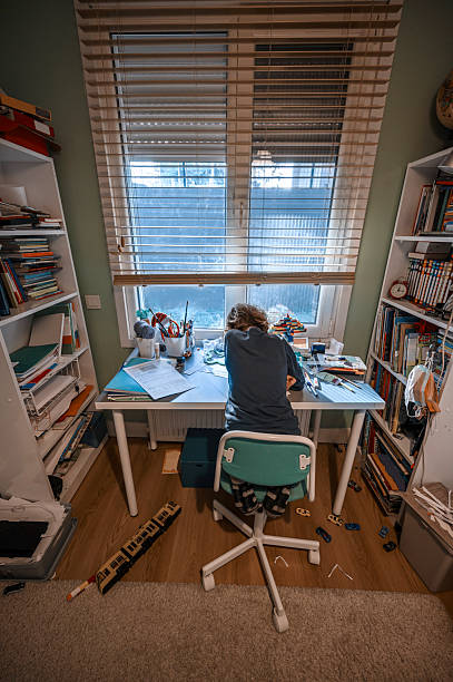 istock Child doing homework in messy room at home 2216863709