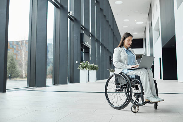 istock Young Businesswoman with Disability Using Laptop in Lobby 2216866025