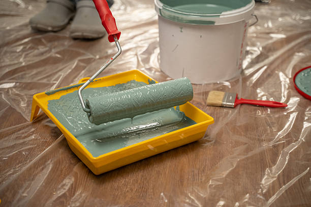 istock Painter dipping paint roller in tray for home renovation project 2216876328