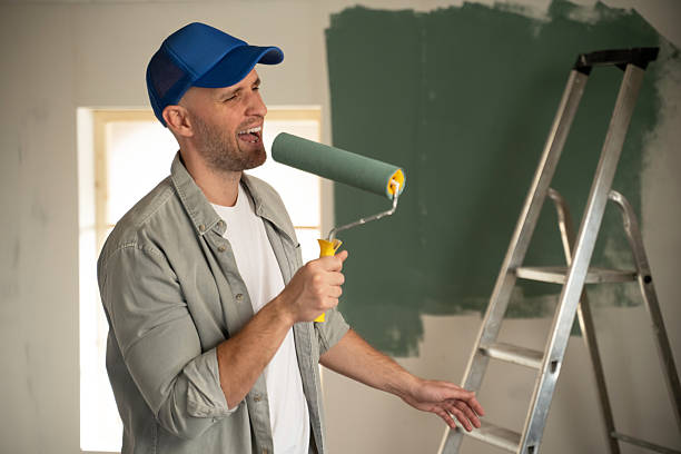Painter singing with paint roller during home renovation stock photo