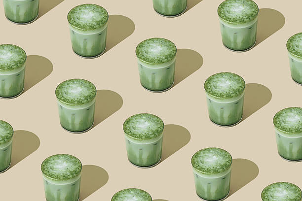 Creative summer pattern made of iced matcha latte on beige background. Minimal healthy matcha latte concept. Trendy drink idea.
