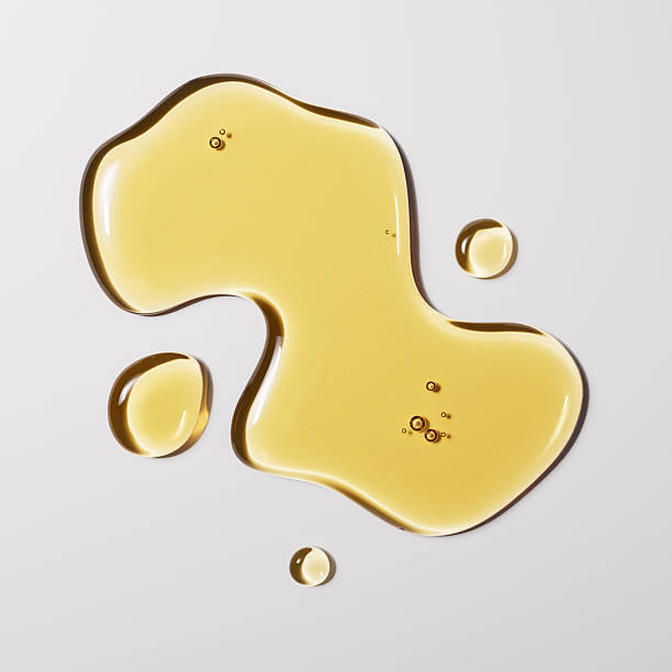 Golden liquid jojoba oil drops, olive oil texture abstract background, 3d rendering Golden liquid jojoba oil drops, olive oil texture abstract background, 3d rendering facial oil stock pictures, royalty-free photos & images