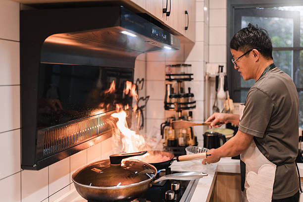 Asian man cooking alone in the kitchen. A healthy start to the day.