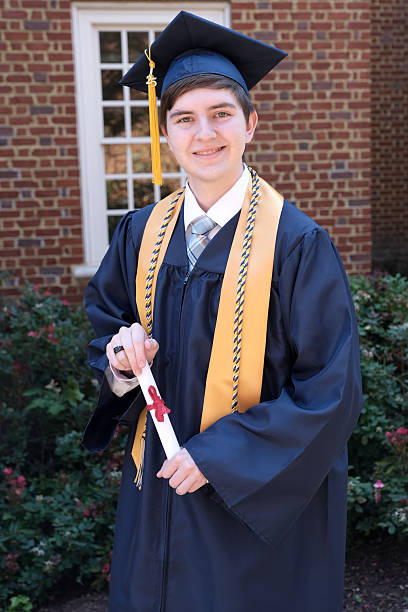 istock High School student wearing cap and gown. 2216890575