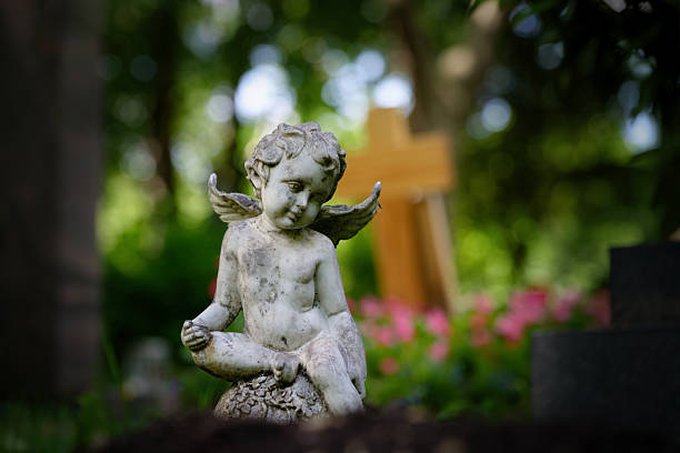 istock weathered putto sits on an ornate sphere on a grave 2216895561