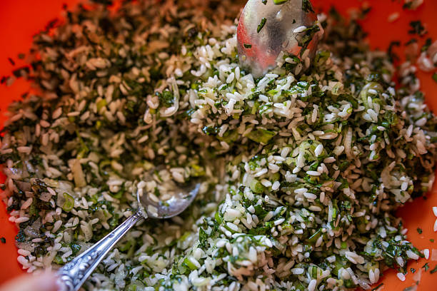 Healthy vegetarian risotto, prepared of integral rice, mushrooms, cherry tomato and fresh vegetables, local seasoning, herbs and spices, served in a  beautiful ceramic bowl on a traditional rustic light wooden table, representing a healthy lifestyle and healthy eating, a city life, wellbeing and a joy