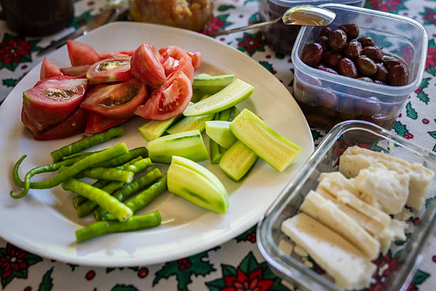 Traditional Turkish breakfast table is ready for eat in living room.\nTomato, salad, cucumber, cheese.