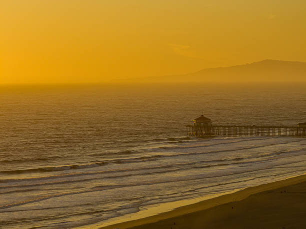 An aerial image of Huntington Beach Pierr during a hazy, glowing sunset.