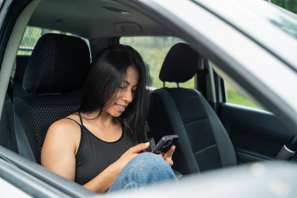 istock Woman checking her phone inside the car 2216901186